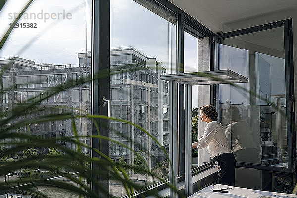 Businesswoman standing in office  looking out of window