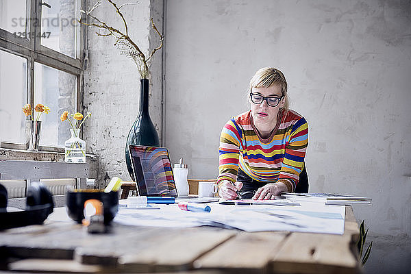Portrait of woman working at desk in a loft