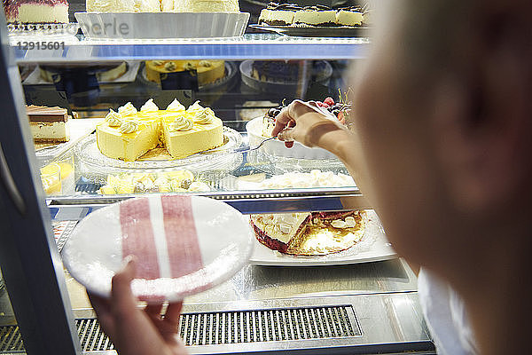 Woman working in a cafe serving a piece of cake