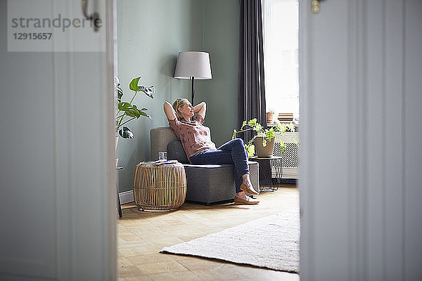 Relaxed mature woman sitting at home