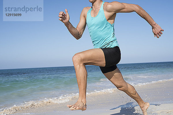 Spain  Canary Islands  Fuerteventura  young man exercising on the beach