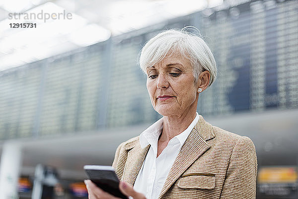 Senior businesswoman using cell phone at the airport
