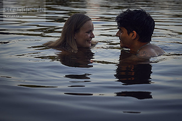 Romantic couple embracing in lake at sunset