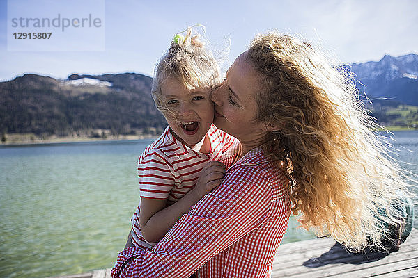 Austria  Tyrol  Walchsee  happy mother carrying daughter at the lake
