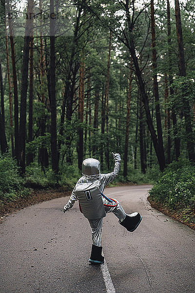 Spaceman exploring nature  standing on road in foreat
