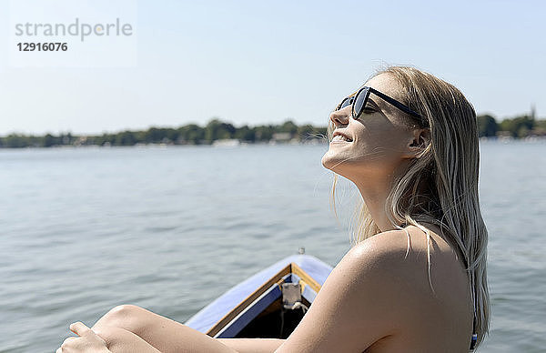 Germany  Brandenburg  smiling blond woman sunbathing on Zeuthener See