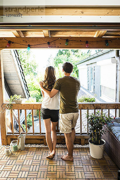 Rear view of couple standing on balcony