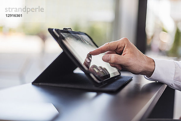 Close-up of businessman using tablet in a cafe