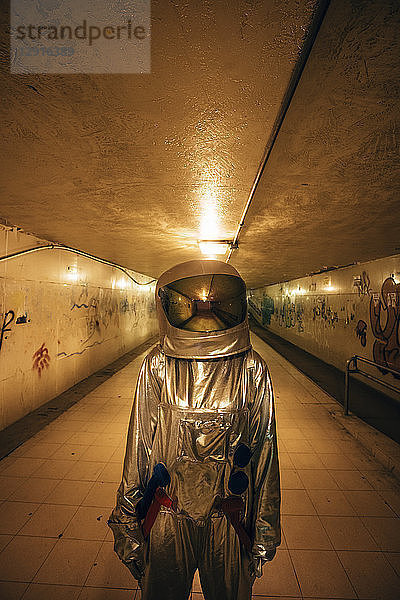 Spaceman in the city at night standing in underpass