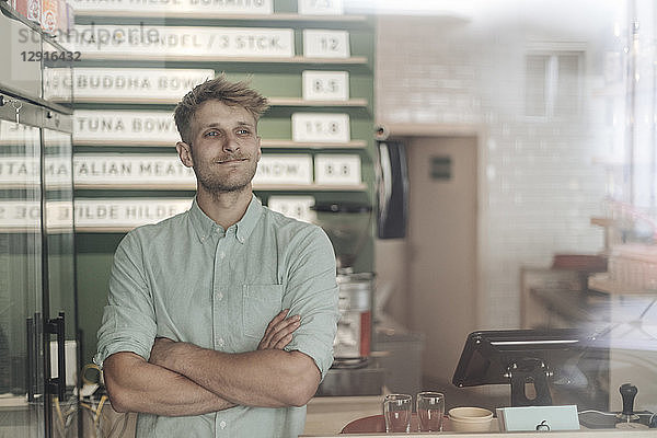 Young man working in his start-up cafe  portrait