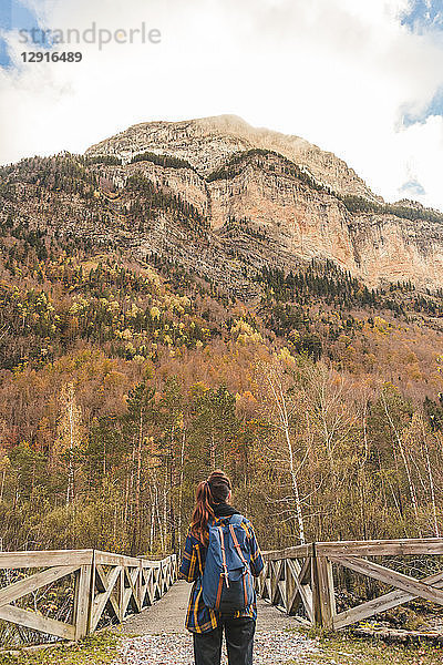 Spain  Ordesa y Monte Perdido National Park  back view of woman with backpack in autumn