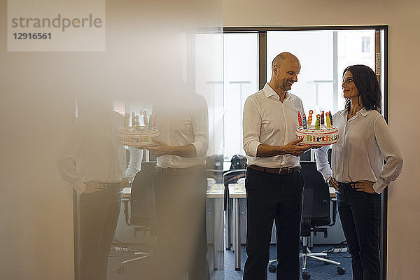 Businessman gifting his colleague with a birthday cake in office