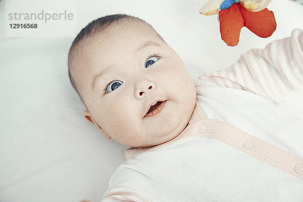 Smiling baby lying on bed  portrait