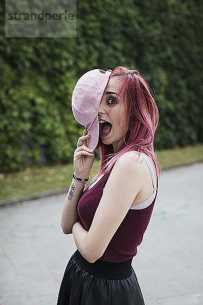 Portrait of cheerful young woman with dyed hair outdoors