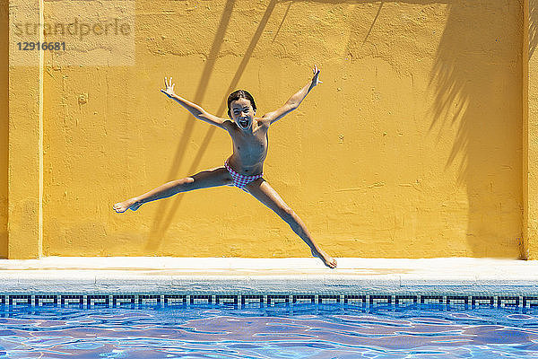 Young girl jumping in the pool