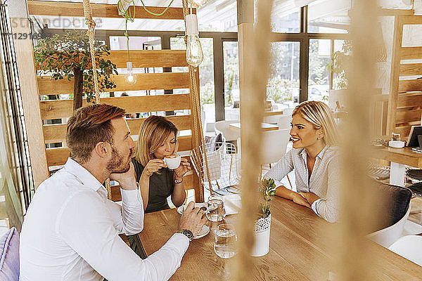Three friends meeting in a cafe