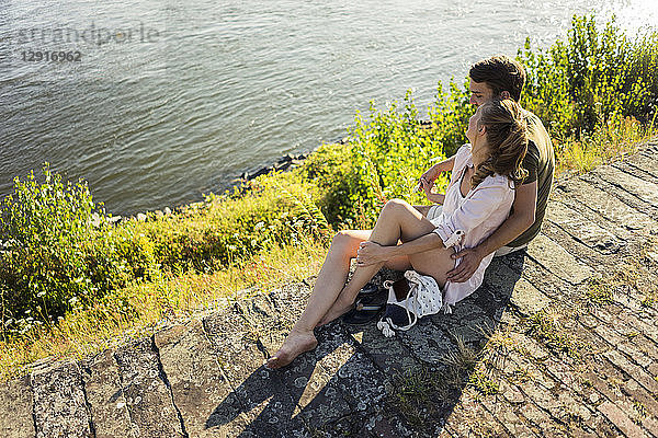 Happy couple relaxing at the riverside in summer