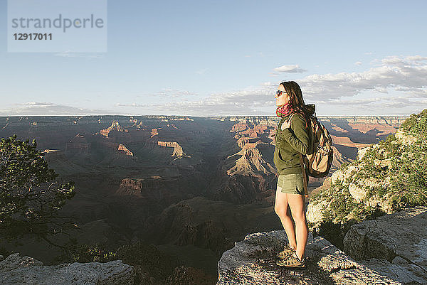 USA  Arizona  Grand Canyon National Park  Young woman with backpack exploring and enjoying the landscape at sunset