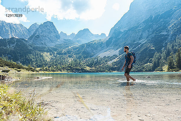 Austria  Tyrol  Hiker at Lake Seebensee walking ankle deep in water