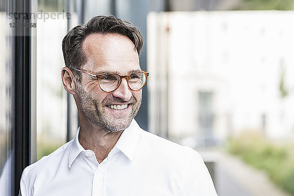 Portrait of smiling businessman with stubble wearing glasses