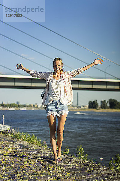 Portrait of carefree woman at the riverside in summer