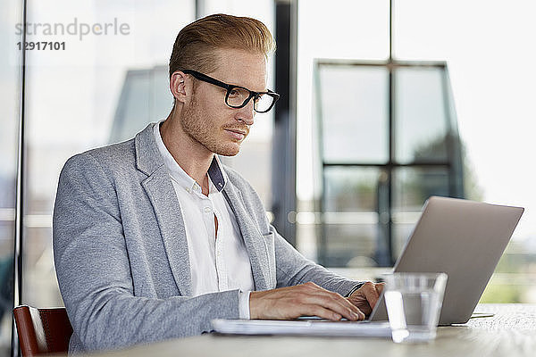 Businessman using laptop on desk in office
