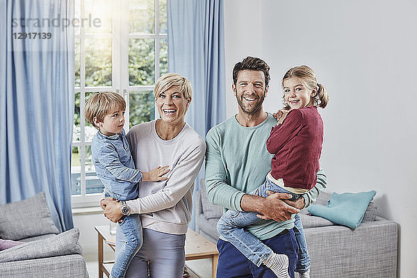 Portrait of happy family with two kids at home