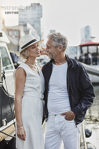 Older man and young woman at a marina next to a yacht