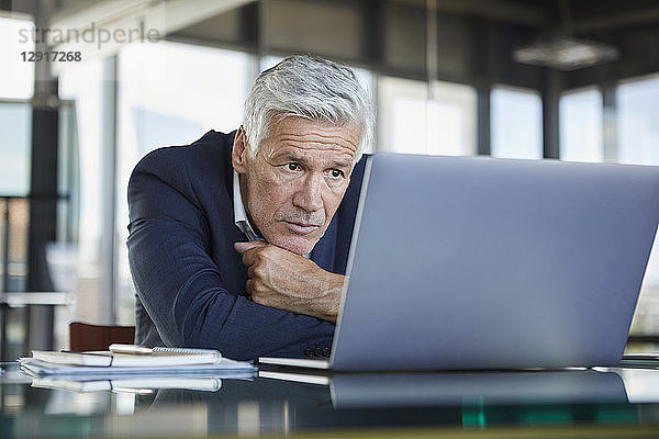 Businessman sitting at desk  trying to solve a problem