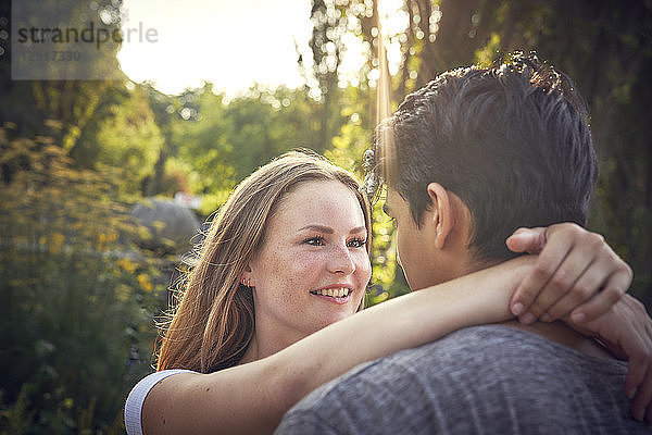 Happy young couple flirting in a park in summer