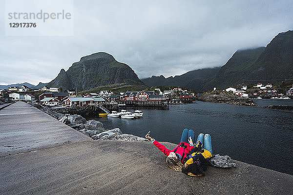 Norway  Lofoten  two young women lying on a pier at the coast taking a selfie