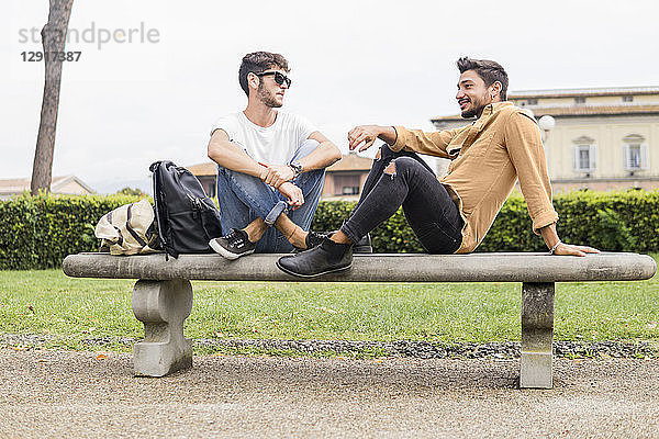 Young gay couple relaxing on bench