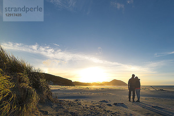 New Zealand  South Island  Puponga  Wharariki Beach  Couple on the beach at sunset