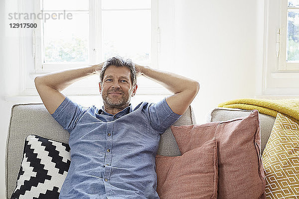 Man sitting on couch at home  relaxing