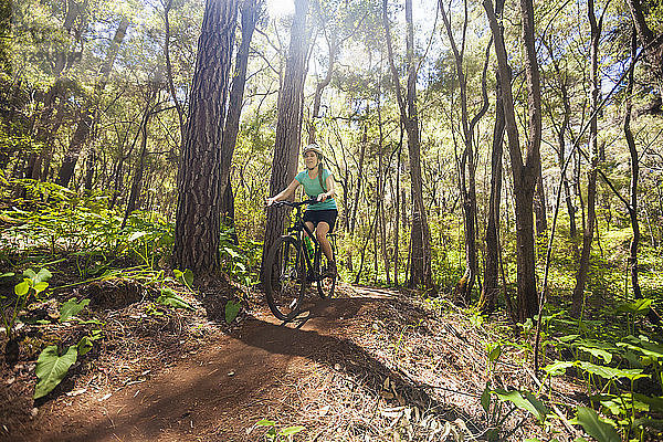 Frontansicht einer jungen Frau beim Mountainbiking im Wald auf den Pines Trails  Margaret River  Westaustralien  Australien