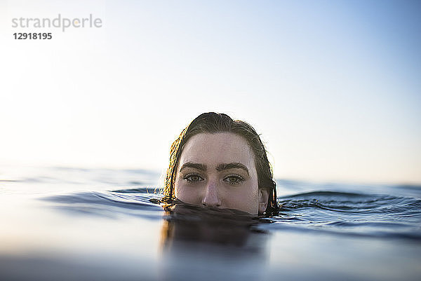 Hochschnittaufnahme einer jungen Frau  die im Meer schwimmt  Gesicht tief im Wasser