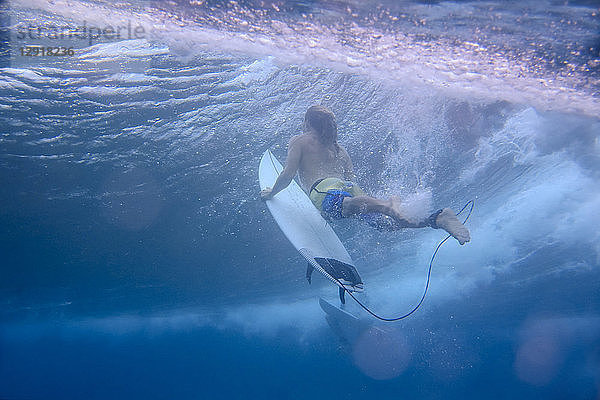 Unterwasseransicht eines männlichen Surfers beim Tauchen im Meer  Male  Malediven