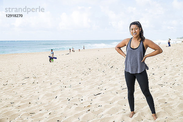 Starke junge Frau steht am Sandstrand an der Nordküste von Oahu bei Tageslicht  Hawaii  USA