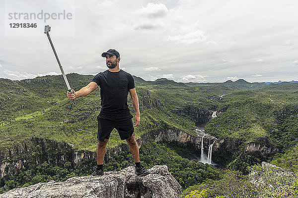 Mann macht Selfie mit Selfie-Stick in Cerrado-Landschaft  Chapada dos Veadeiros  Goias  Brasilien