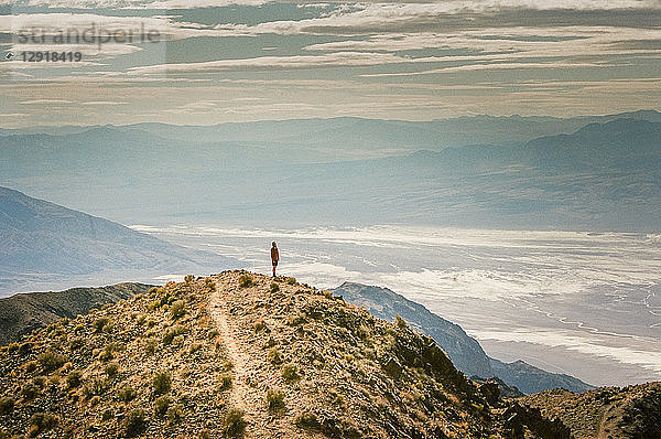 Ein Mann steht auf einem Gipfel und blickt über das Death Valley bei Dantes View  Kalifornien  USA