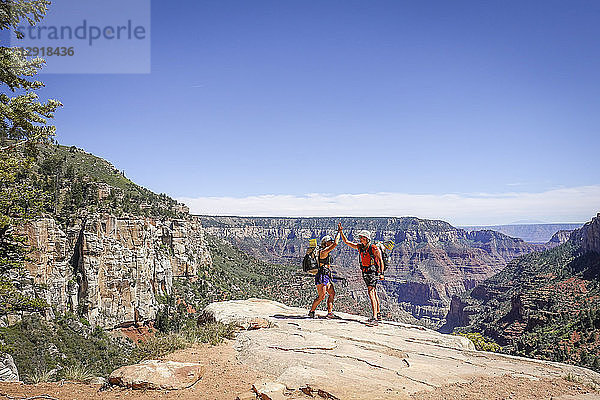 Zwei Wandererinnen geben sich die Hand  nachdem sie den steilen Aufstieg aus dem Grand Canyon geschafft haben  Arizona  USA