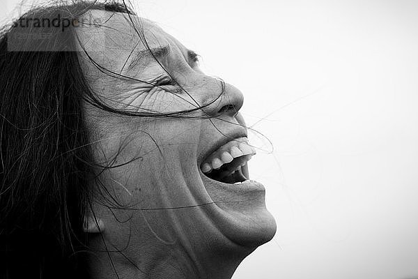 Seitenansicht KopfschussÂ einer lachenden Frau mit schwarzen Haaren