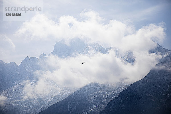 Ein Hubschrauber fliegt durch die Wolken des Himalayas.