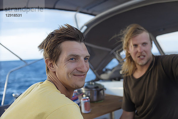 Blick auf zwei junge Männer auf einem Segelboot