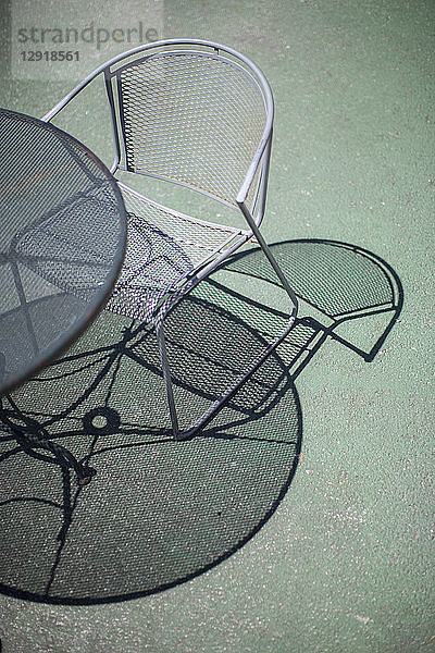 Hochformatige Ansicht von Tisch und Stuhl mit Schatten  die sich auf der Terrasse spiegeln  Santa Cruz  Kalifornien  USA