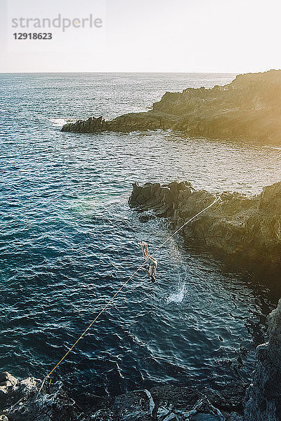 Junger Mann  der beim Versuch  ein Küstengewässer zu überqueren  vom Drahtseil fällt ¬ÝTeneriffa  Kanarische Inseln  Spanien