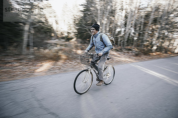 Junger Mann fährt mit dem Fahrrad auf einer Landstraße  Peaks Island  Maine  USA