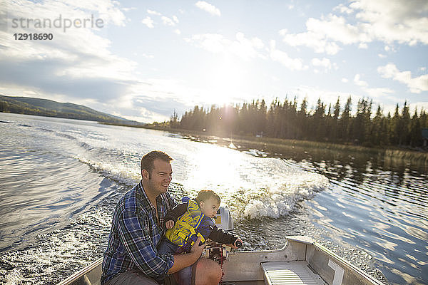 Blick auf Vater und Sohn  die gemeinsam Zeit auf einem Motorboot auf einem See verbringen  Kamloops  British Columbia  Kanada