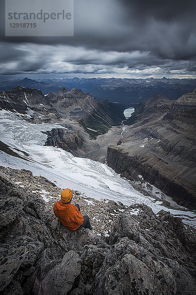 Blick von oben auf einen Wanderer mit Schutzhelm  der in den Bergen sitzt  Lake O'Hara  Yoho National Park  Alberta  Kanada