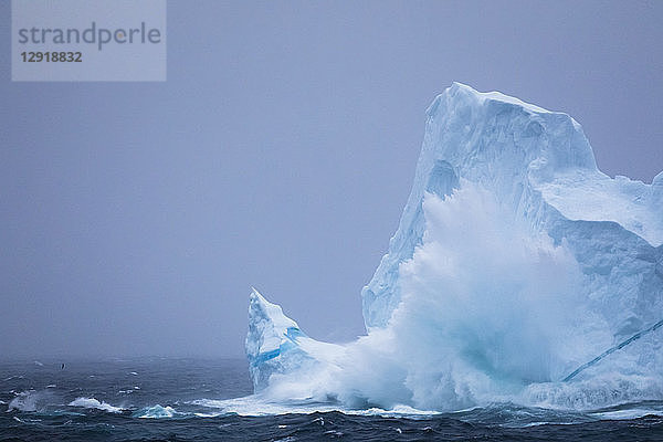 Riesige Wellen prallen bei einem Sturm 12 Meilen vor der Küste der Westfjorde in Island auf einen Eisberg